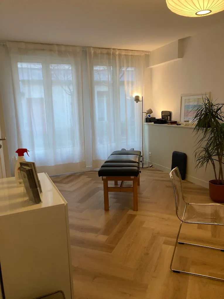 Salle de traitement du cabinet de chiropraxie Paris 11ᵉ, fenêtres voilées et table de soin